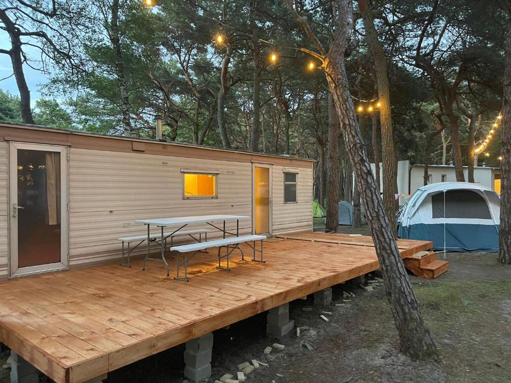 赫尔Your Caravan Hel的小木屋设有木甲板上的桌子和长凳