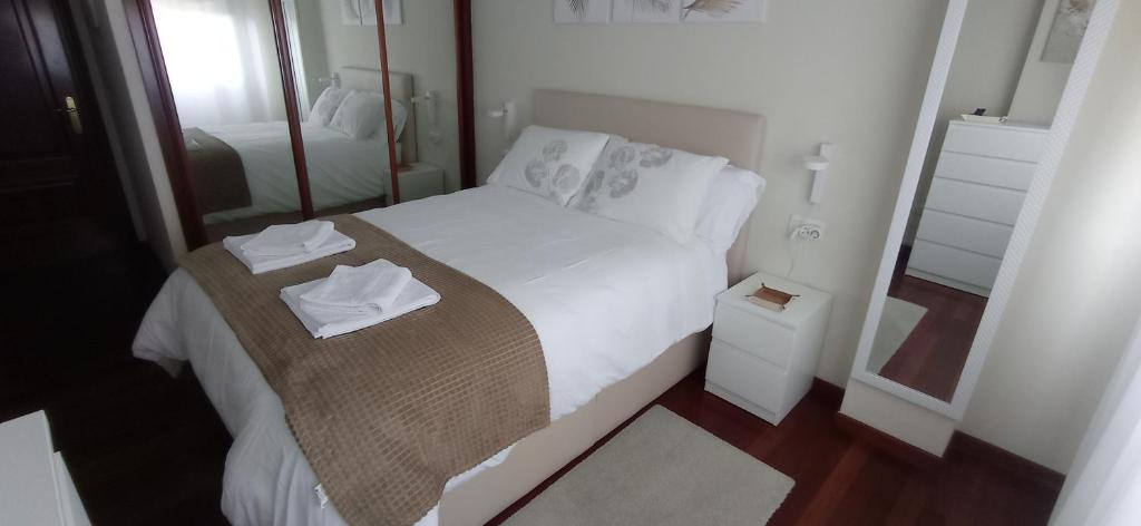 维戈Val do Fragoso的一间小卧室,配有一张带镜子的白色床