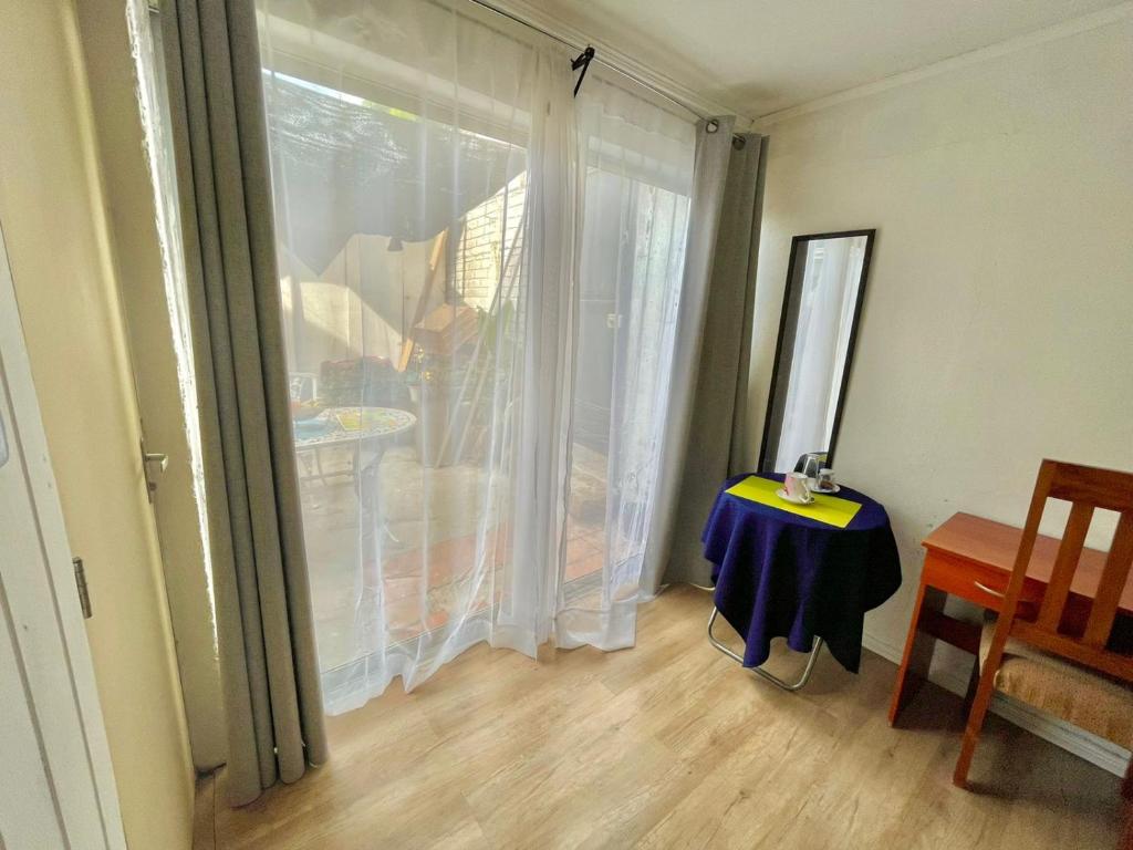 奇廉Hostal Dulces Sueños的一间设有滑动玻璃门、桌子和窗户的房间