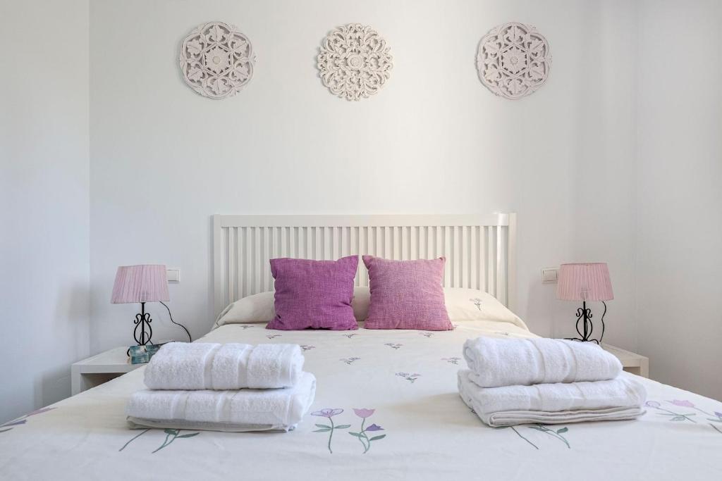 韦尔瓦Adosado Cigüeñas IV-Islantilla Golf的卧室配有白色床和紫色枕头