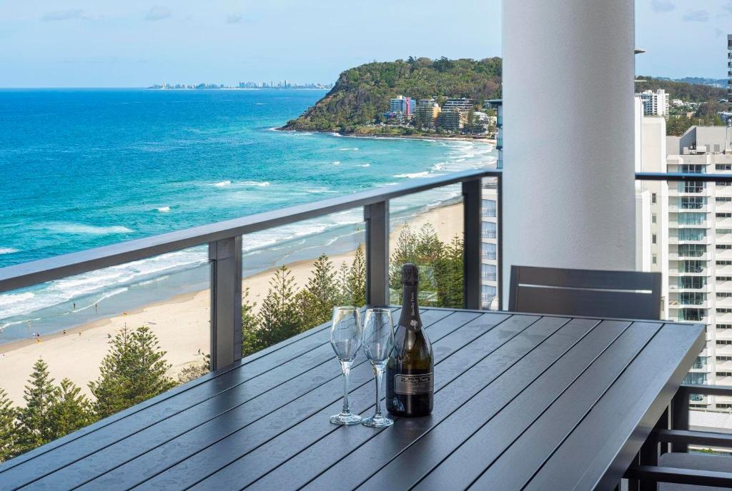 黄金海岸Breathtaking Burleigh Beach Abode的一张桌子,上面放着一瓶葡萄酒和两杯酒杯