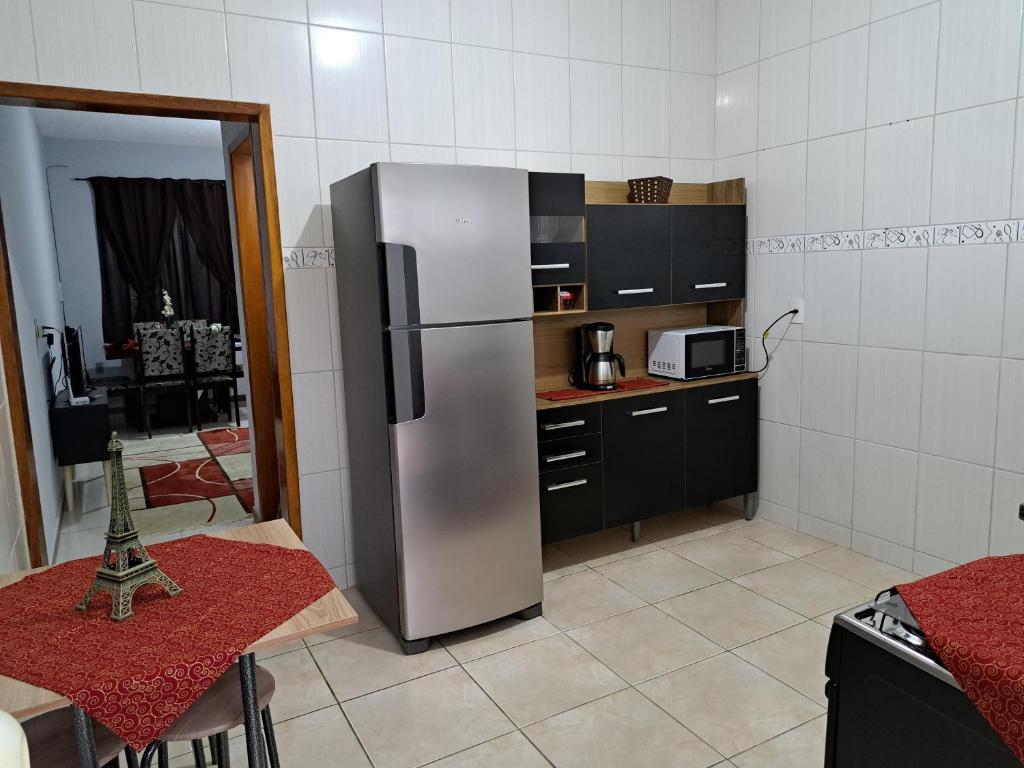 安格拉杜斯雷斯Casa aconchego Parque Mambucaba的厨房配有不锈钢冰箱和桌子