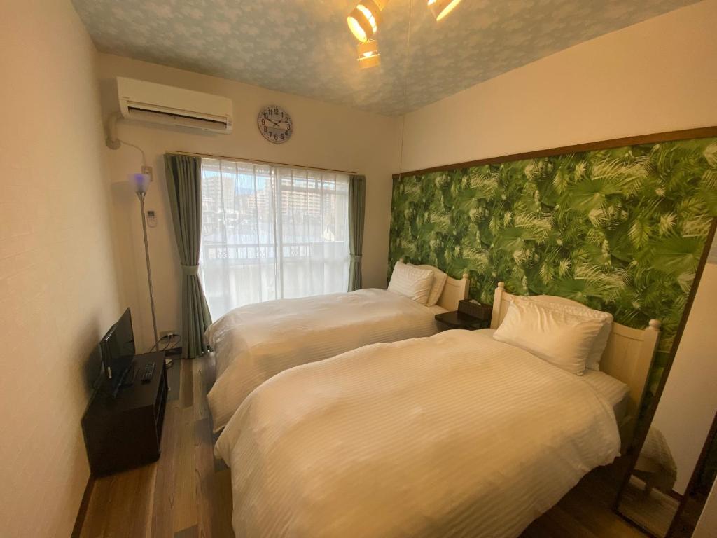 福冈ラ・ポート空港前201的酒店客房带两张床和壁画