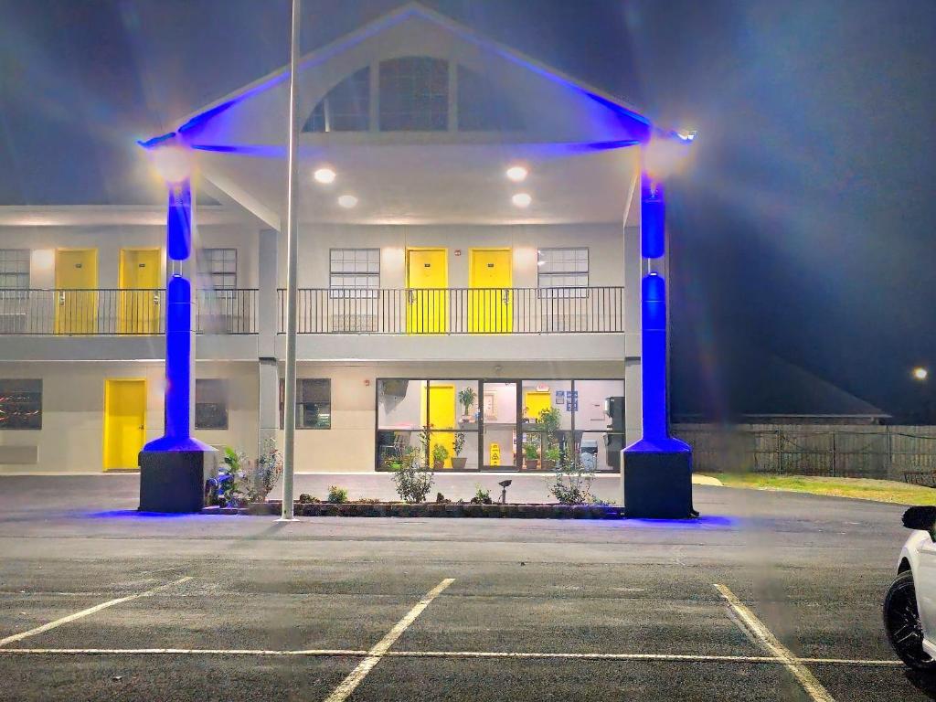 麦卡莱斯特SureStay by Best Western McAlester的停车场内有蓝色灯光的建筑