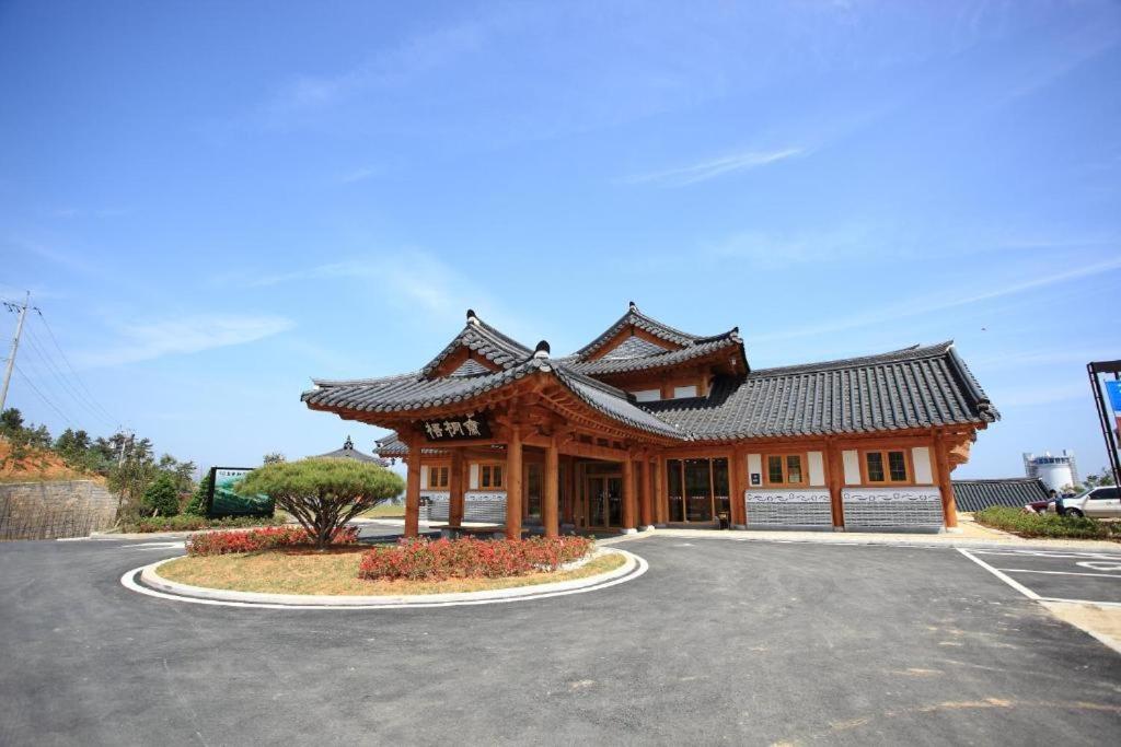 丽水市Korea Traditional Hotel O Dong Jae的停车场内有屋顶的大型建筑