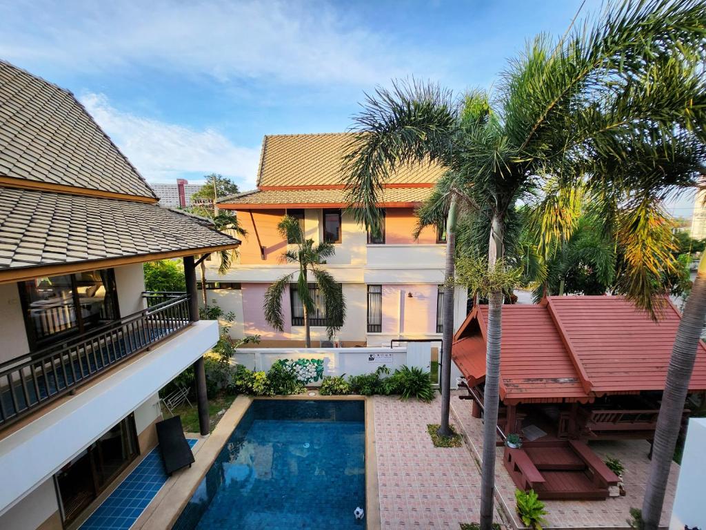 乔木提恩海滩ปุณณภา พูล วิลล่า พัทยา Punnapha Pool Villa Pattaya的享有带游泳池和棕榈树的别墅的空中景致