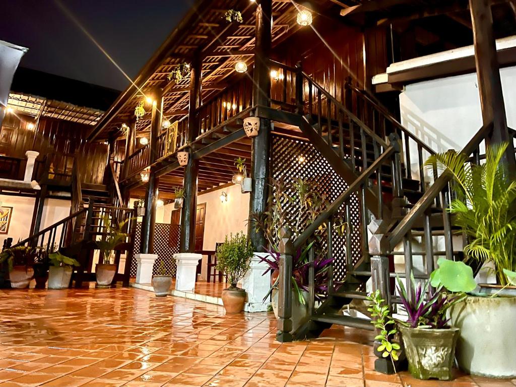 琅勃拉邦Vieng Savanh II Hotel的大厅里种有盆栽植物和楼梯