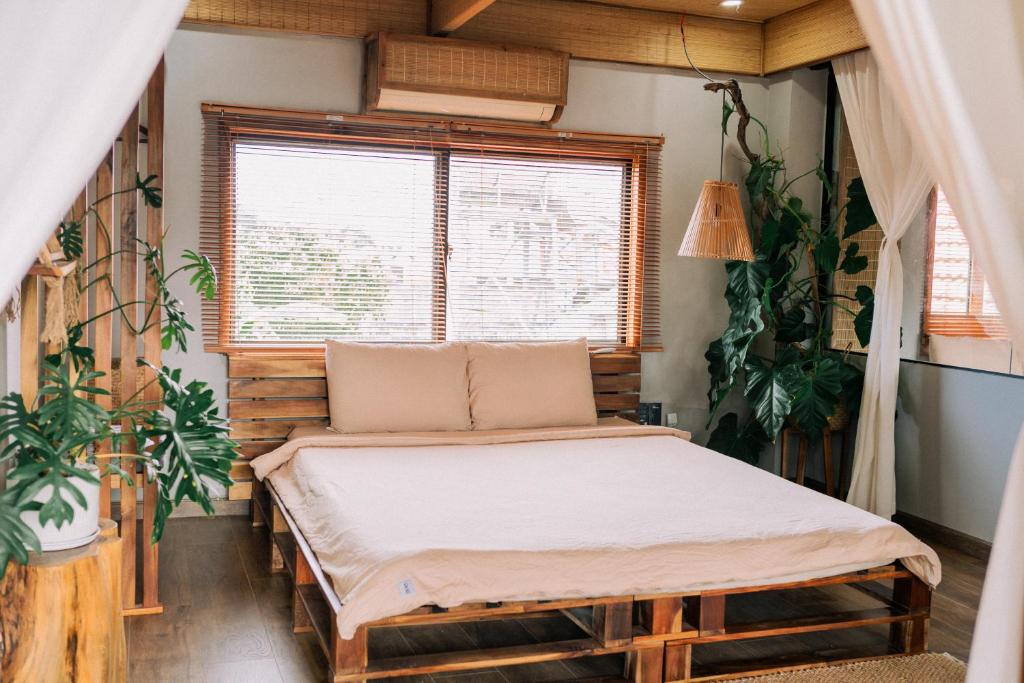 富国TỊNH House Phú Quốc的植物间内一间卧室,配有一张床