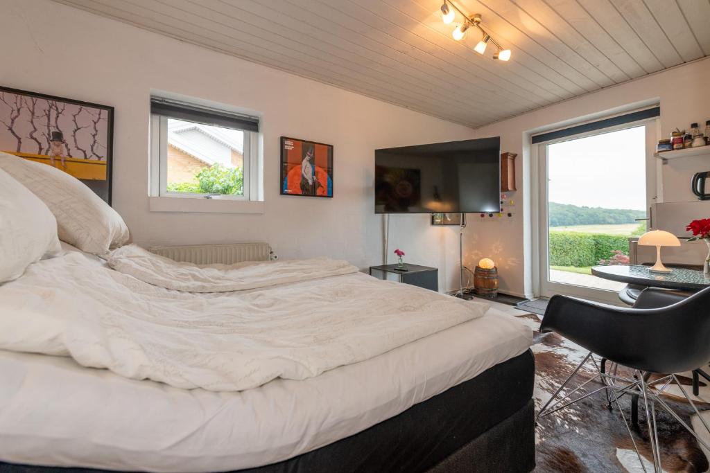 霍森斯Bed & Breakfast Horsens - Udsigten的一张大床,位于带大窗户的房间里