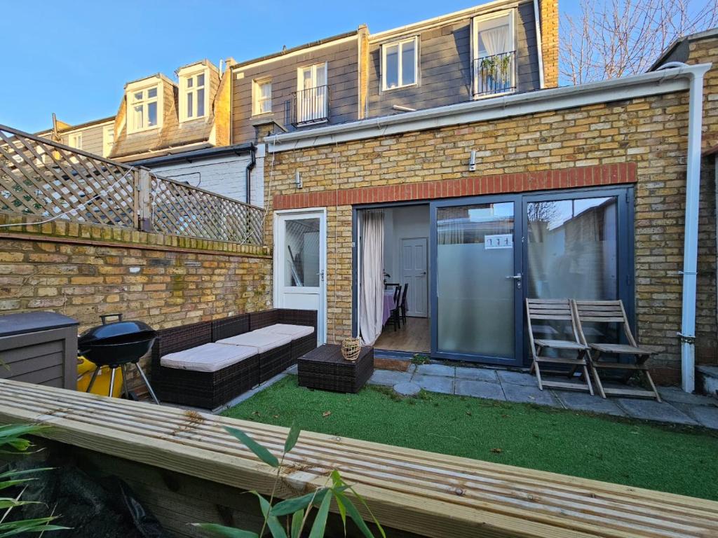 伦敦Putney Thames garden flat的砖屋,设有长凳和庭院