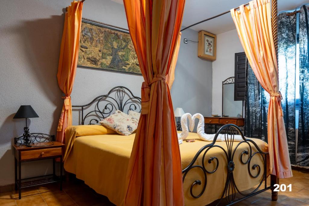 乌娜Hotel Uña Serranía Encantada的一间卧室配有一张带橙色天篷的床