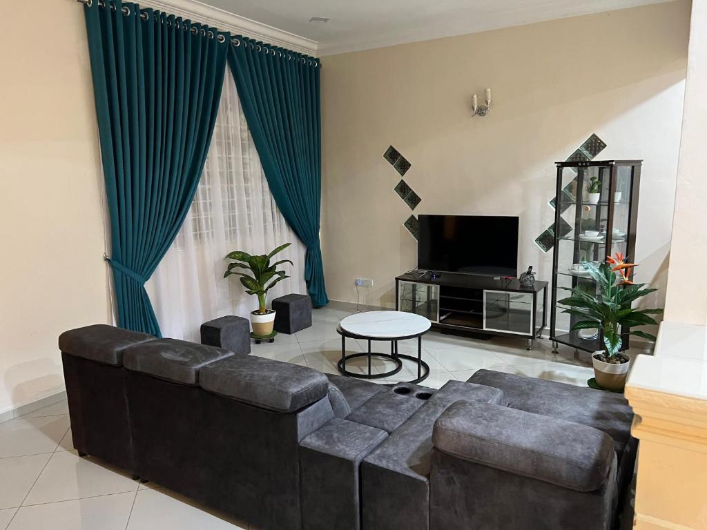 MerlimauMutiara Villa Homestay - Comfort Away From Home的客厅配有沙发和桌子