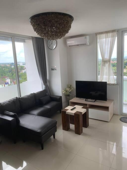 日惹2BR VIVO Apartement by MJP的客厅配有黑色沙发和电视