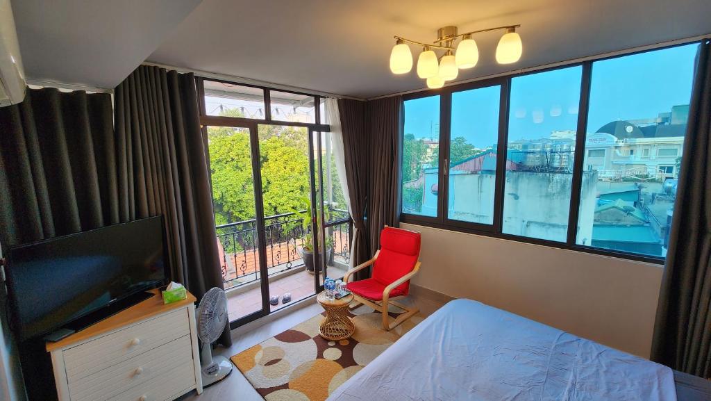 河内T Home Balcony的卧室设有红色椅子和大窗户