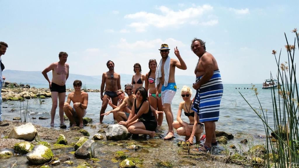 提比里亚太巴列旅舍的一群人站在海滩的水面上