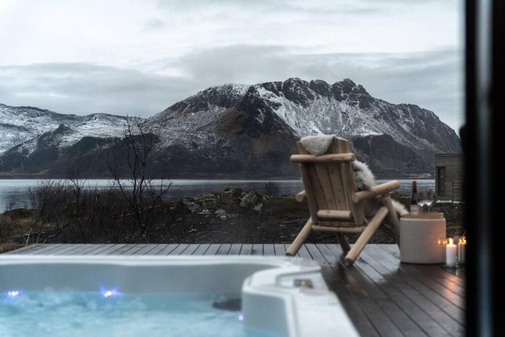 LyngværetLuksushytte med Jacuzzi, Summer&Winter Retreat的坐在带山的浴缸旁的椅子