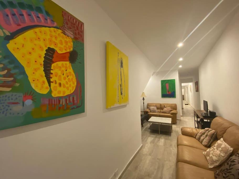 圣保罗湾城Beach House. Live, experience sea的客厅配有沙发和墙上的绘画