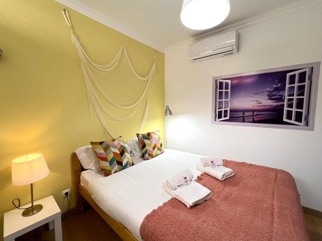 奥良Olhão Beach Apartment 2 by Homing的一间卧室配有一张床,上面有两条毛巾