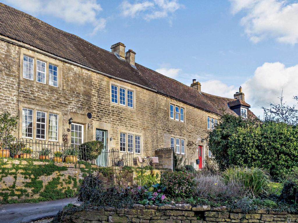 埃文河畔布拉德福1 bed property in Bradford-On-Avon 82251的一座古老的砖房,前面有一个花园