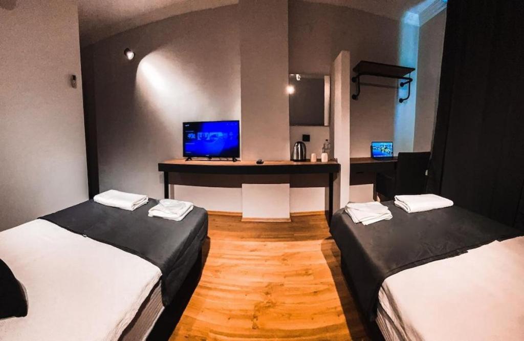 安塔利亚TEPE HOTEL&BUSINESS SUITE的客房设有两张床、一张书桌和电视