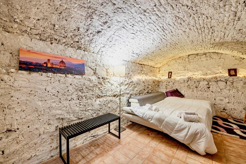 佛罗伦萨"Florence Cave Central Suite" - 5 min To Mandela Forum - 2 Bedrooms - Free Parking的卧室配有一张石墙床