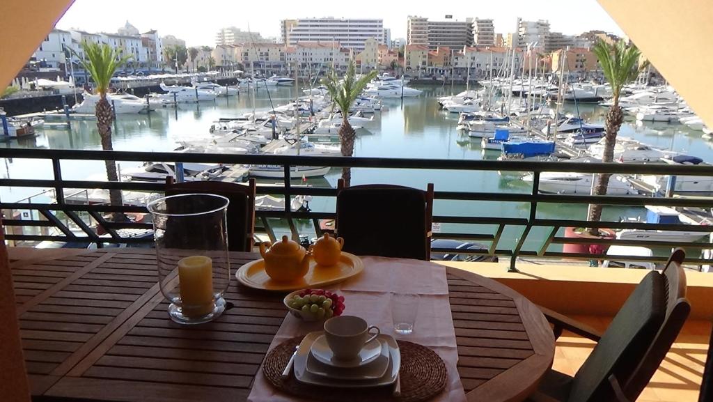 维拉摩拉Beach Apartment Marina Vilamoura的一张桌子,享有码头和船只的景色