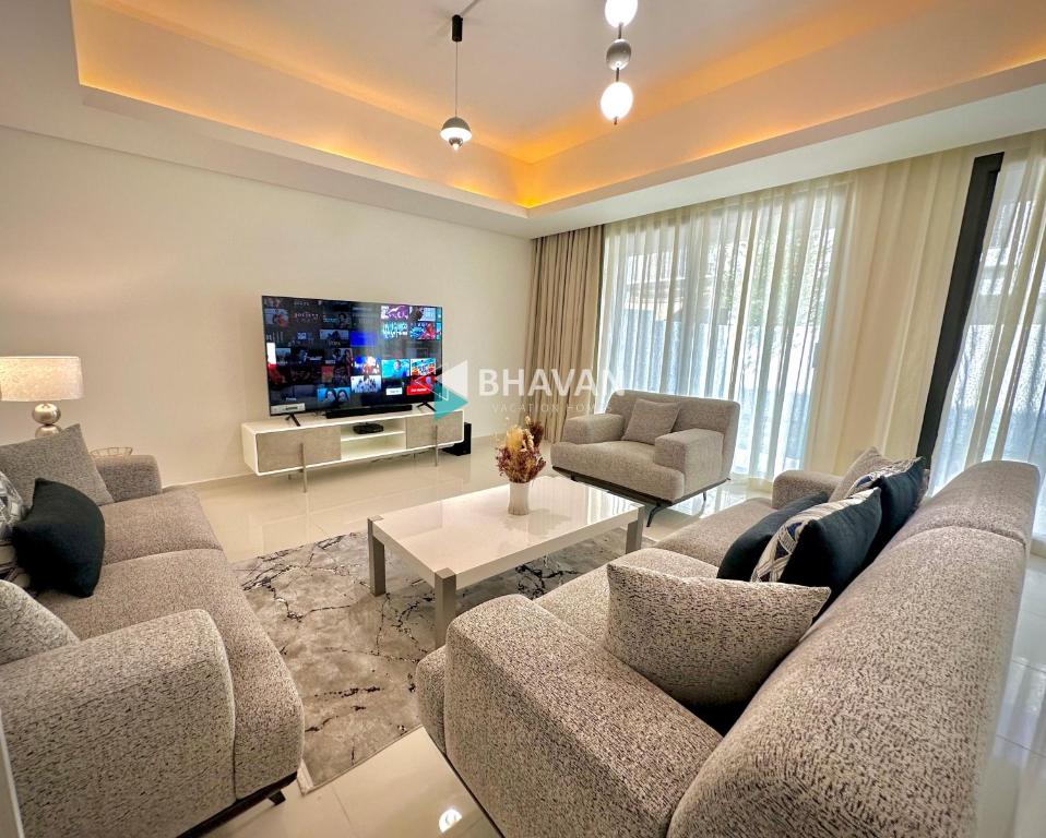 迪拜Calm Chaos 4 BR Villa with maid Room in Damac Hills 2的带沙发和电视的客厅