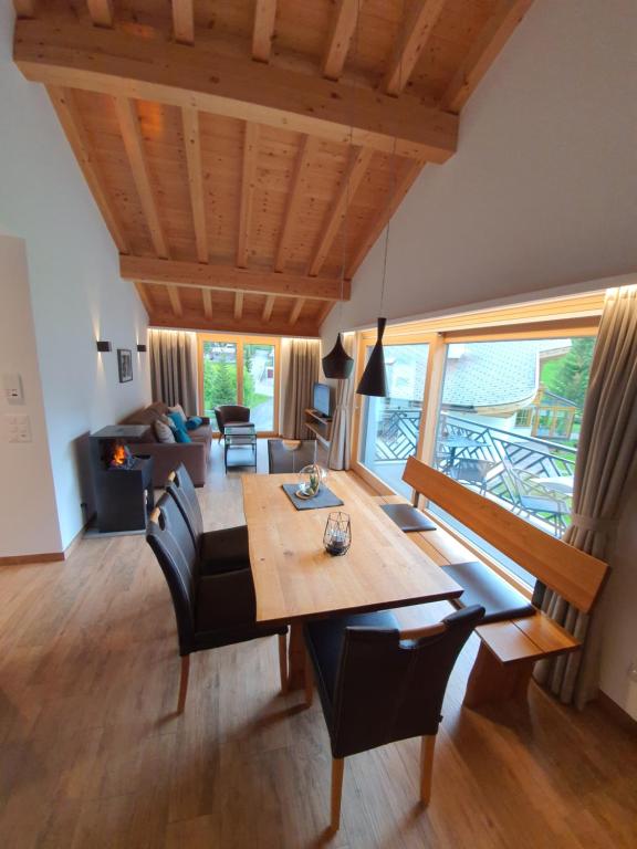 萨姆瑙恩Engadin Lodge PREMIUM & PRIVATE的客厅配有桌子和沙发