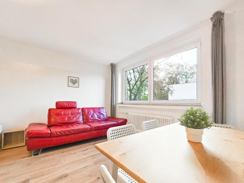 杜塞尔多夫RAJ Living - 2 or 3 Room Apartments - 15 Min zur Messe DUS & 10 Min Old Town DUS的客厅配有红色的沙发和桌子