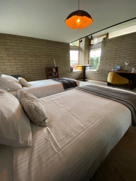 韦姆L’Oxymore的一间卧室配有两张带白色床单和枕头的床。