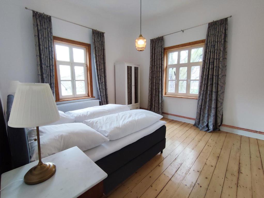 戈斯拉尔Ferienwohnung Goslar mit Parkblick am Harz的一间卧室设有两张床和一张桌子上的台灯。