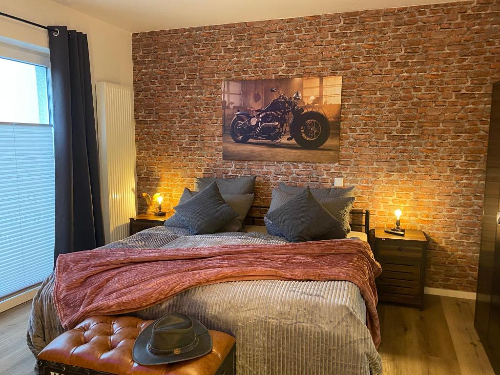 巴特萨尔茨乌夫伦Wild West Appartement的卧室设有砖墙,床上配有摩托车