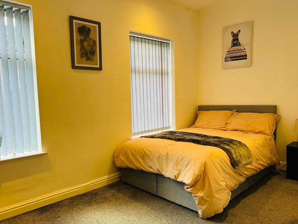 特伦特河畔斯托克Luxury Double & Single Rooms with En-suite Private bathroom in City Centre Stoke on Trent的一间卧室设有一张黄色墙壁和窗户的床