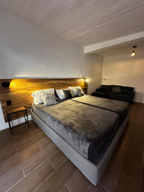圣米格尔-德阿连德Good Hostel的一间卧室配有一张大床和木制床头板