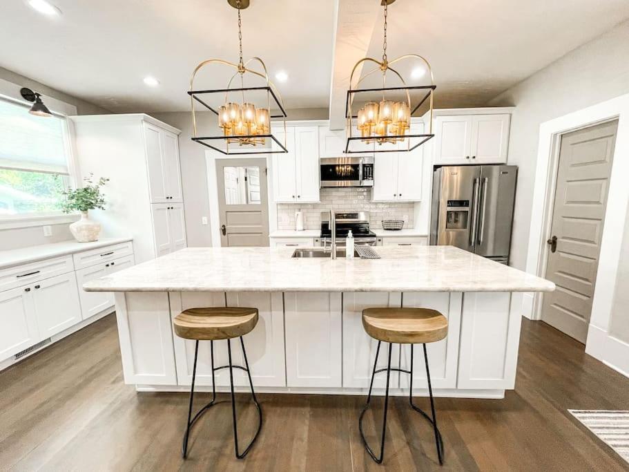 科罗拉多斯普林斯Stunning remodeled Downtown dream home!的一间厨房,配有白色橱柜和一个带凳子的大岛