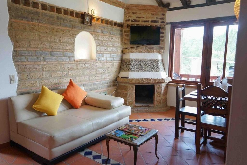 莱瓦镇VILLA CHARLOTTE 2 en colombia的带沙发和砖墙的客厅
