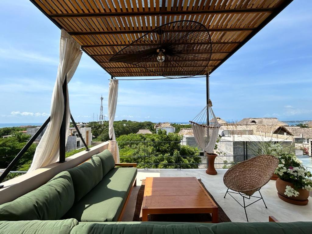 埃斯孔迪多港Casa Dakini en la Punta with pool and ocean view的天井配有沙发、桌子和吊床。