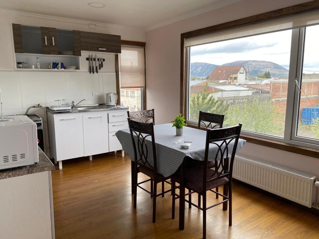 纳塔列斯港Patagonia Tower的厨房配有桌椅和窗户。