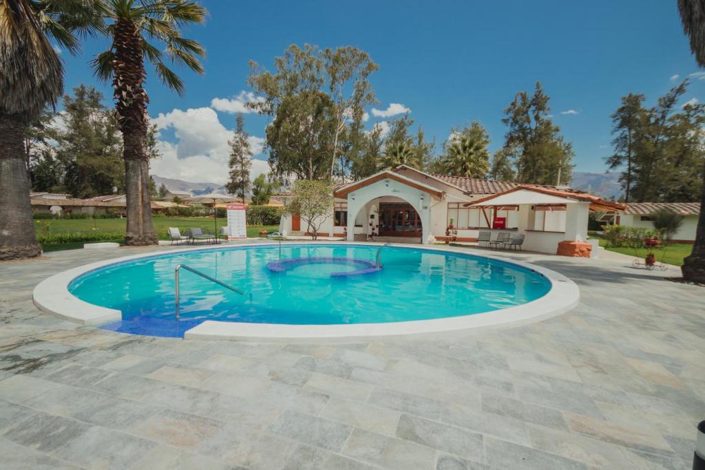 Los Baños del IncaHOTEL & SPA LAGUNA SECA的一座带房子的庭院内的游泳池