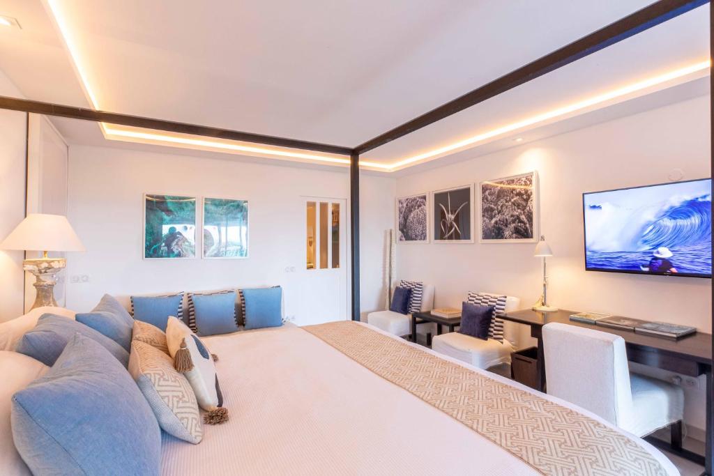 Anse des CayesArt et mer suite Saint barth的一间卧室配有一张大床和蓝色的沙发
