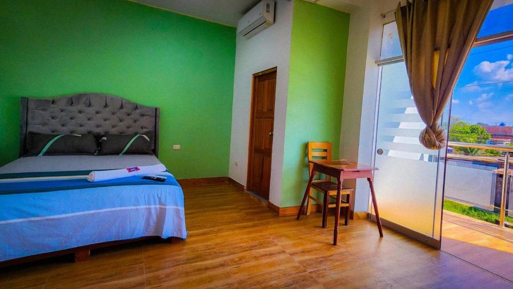 普卡尔帕Hotel LUCHINE的一间卧室设有绿色的墙壁、一张床和一张桌子