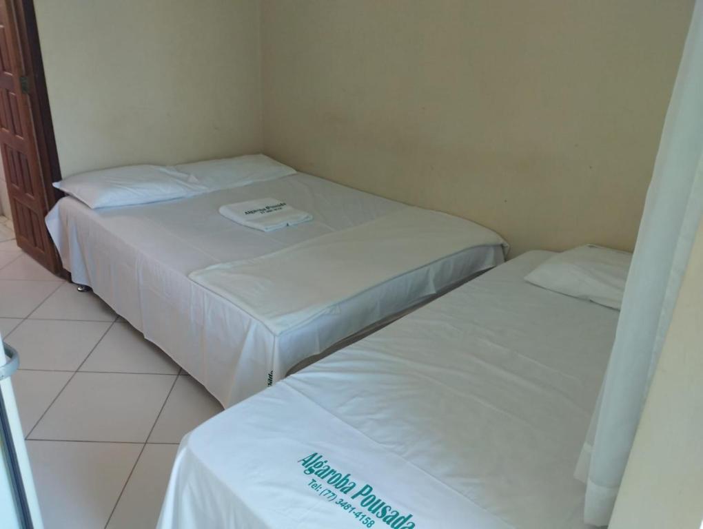 邦热苏斯-达拉帕Hotel Algaroba Anexo的小客房内的两张床,配有白色床单