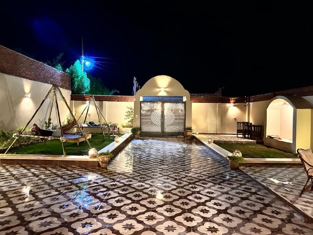 卢克索West Bank luxury villa的一座房子,晚上有石头庭院