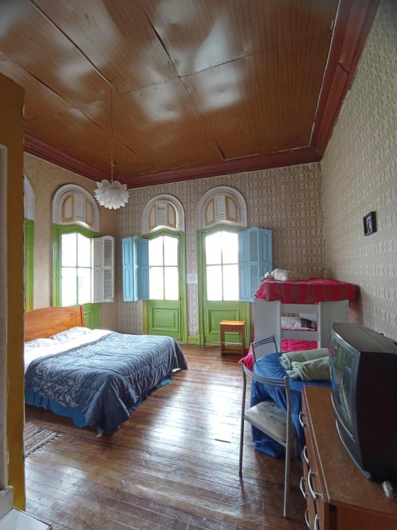 瓦尔帕莱索Hostal del gato的一间卧室配有一张床和一台电视。