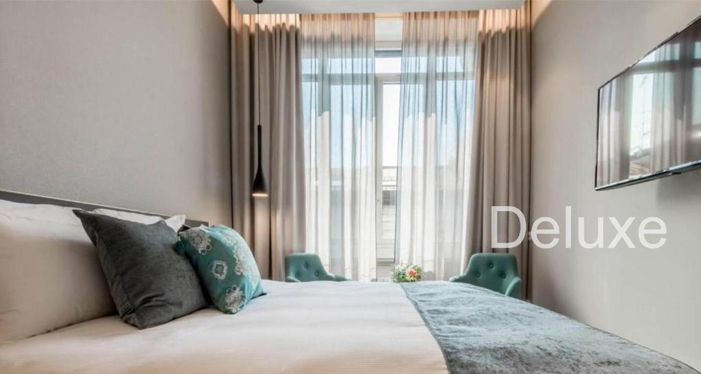 米兰Hotel Vitruvio的一间卧室设有一张床和一个大窗户