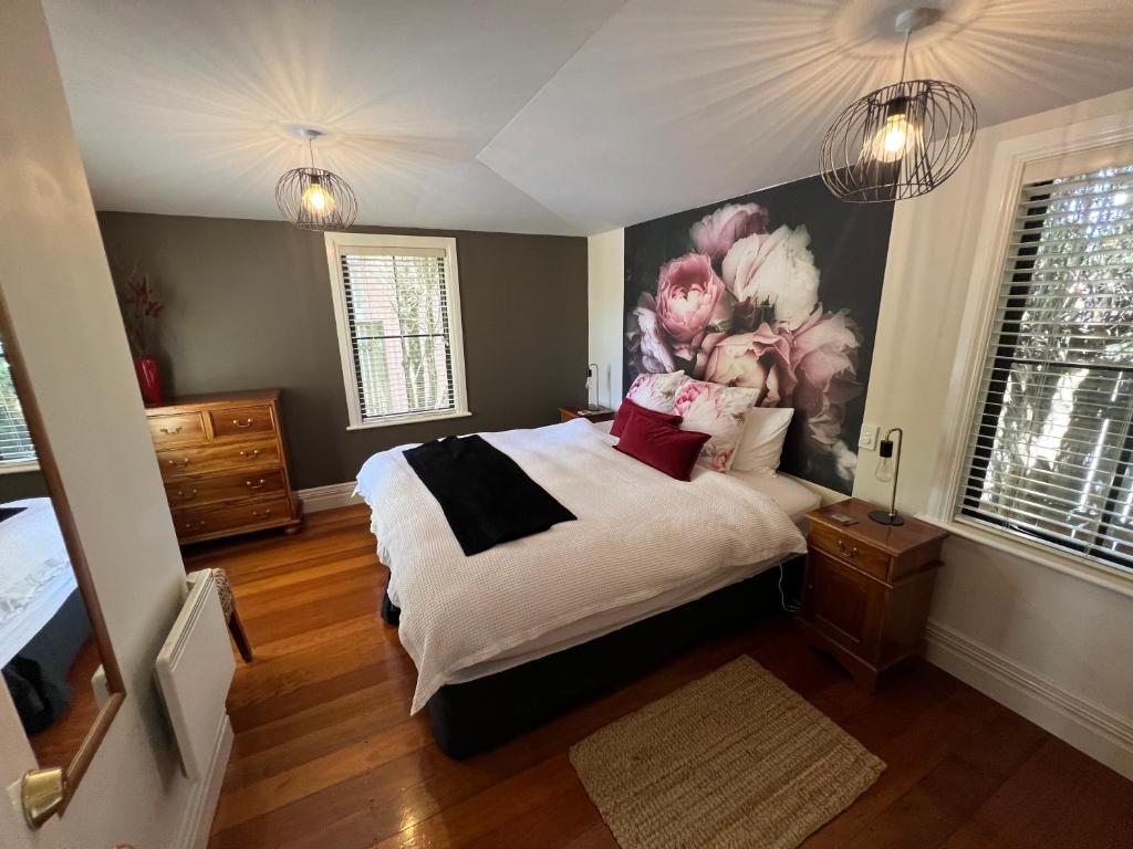 马丁伯勒比诺别墅酒店的卧室配有一张大床,墙上挂有绘画作品
