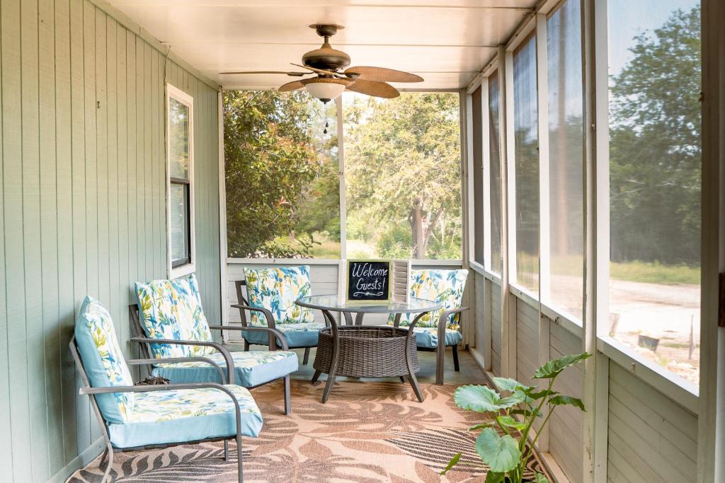 新布朗费尔斯Hadley's House - A Country 3 Bdrm with Screened-In Porch的门廊配有椅子、桌子和吊扇