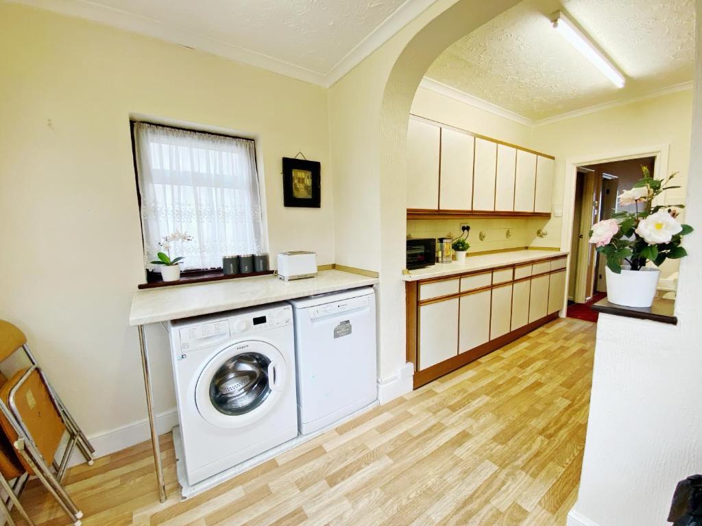 伦敦Barking London House sleeps 11 - parking - train tube - airport的一间厨房,在房间内配有洗衣机和烘干机