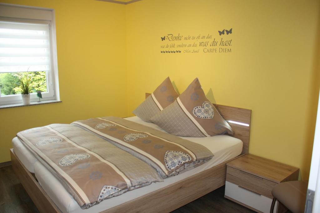 Dutenhofen巴赫曼民宿的卧室配有一张挂有墙上标志的床