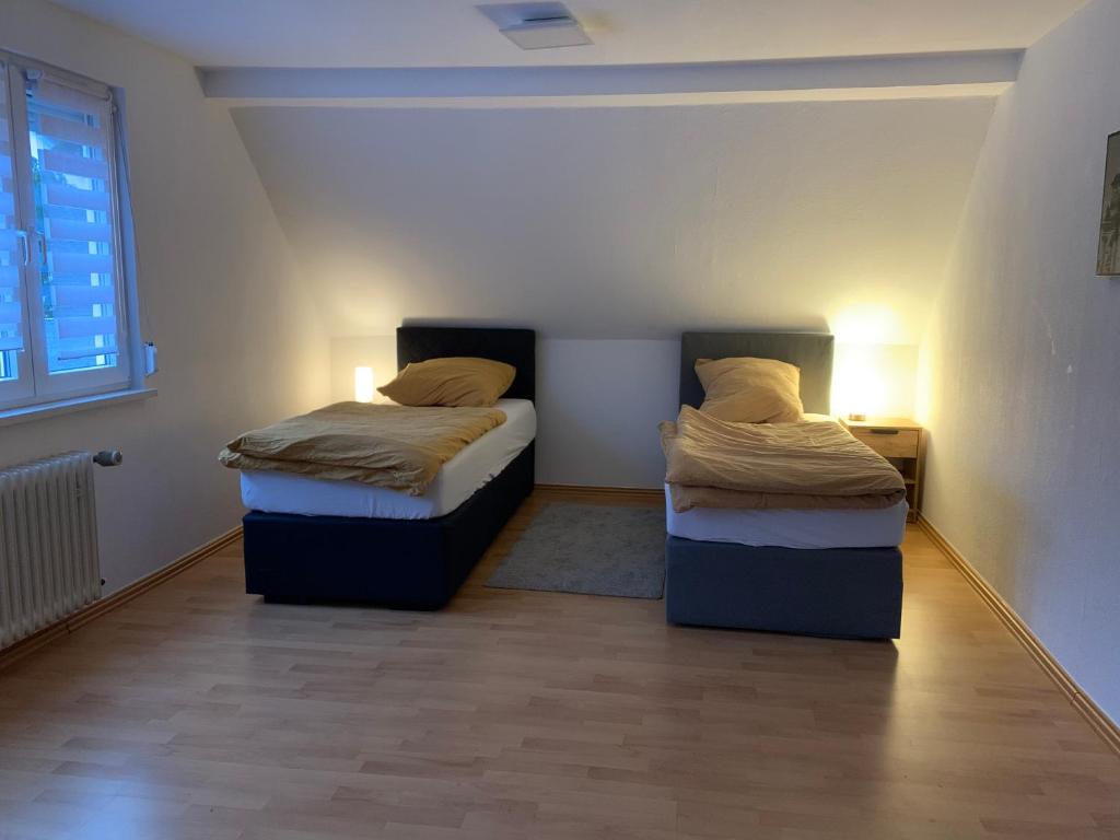 赫尔博恩Ferienwohnung Herborn的配有两盏灯的小房间内的两张床